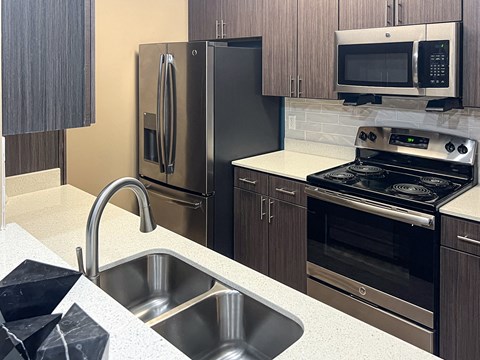 a kitchen with stainless steel appliances and a sink at Canebrake Apartment Homes in Louisiana, 71115